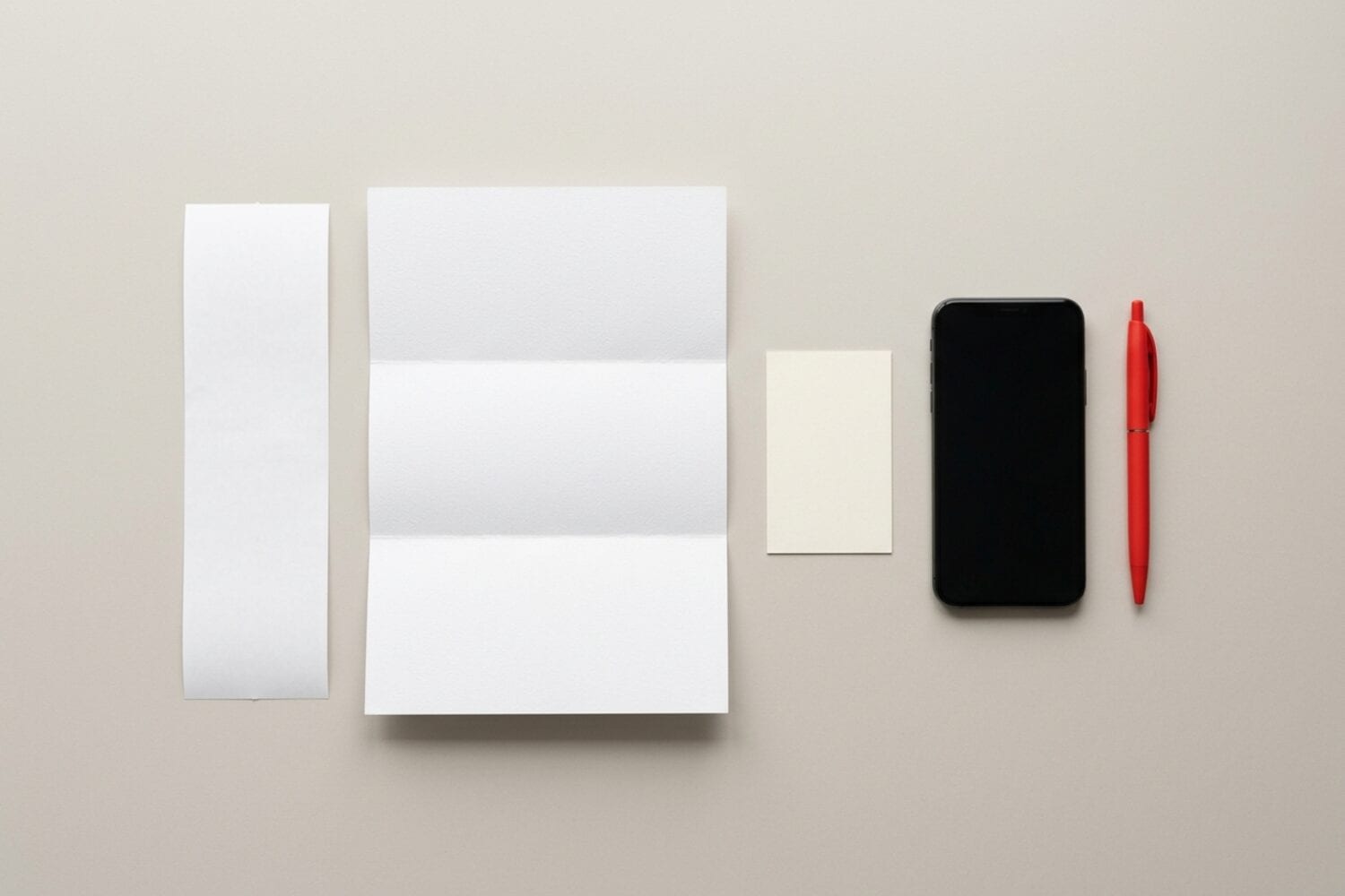 A long receipt, a folded letter, a small card, an iPhone and a red pen laid out for a scanner test