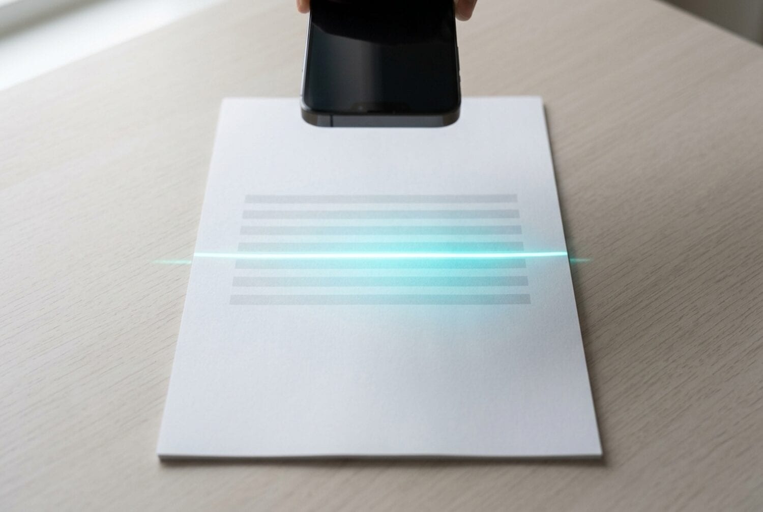 Un iPhone sostenido sobre una hoja de papel plana mientras una fina línea de luz cruza la página